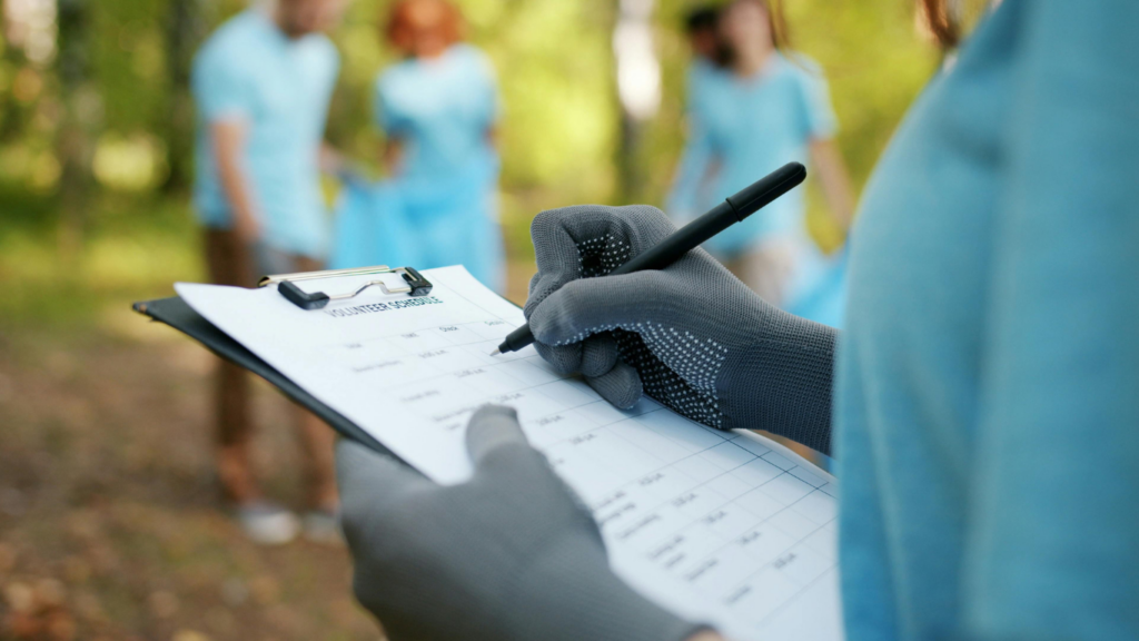 Person writing on clipboard outdoors