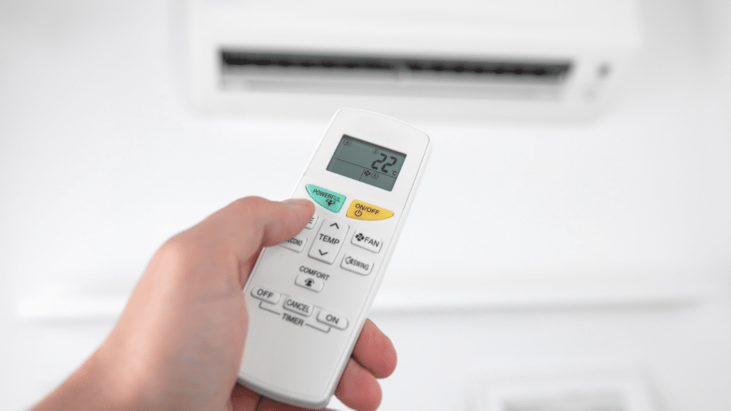 Hand holding air conditioner remote control